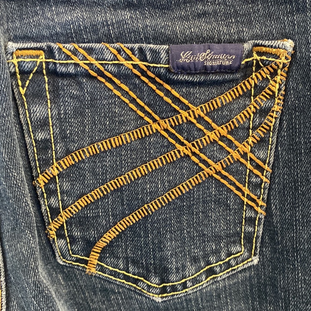 These jeans are in good condition, but the fabric is frayed slightly at bottom.